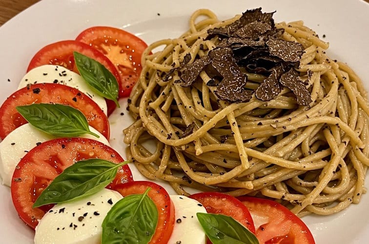 Caprese-Salat serviert zu intensiver Trüffel-Pasta mit Sommertrüffel